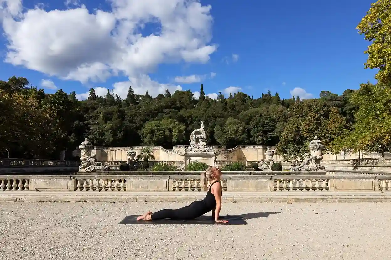 Séance d'œno-yoga au sol devant les fontaines du Jardin de la Fontaine à Nîmes